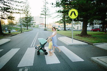 A mother walking her kid with the Greentom Stroller