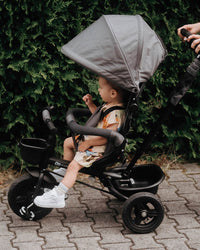 A toddler inside the Kinderkraft Tricycle AVEO