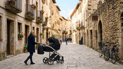 Premium Junama-style stroller being used on a European city street.