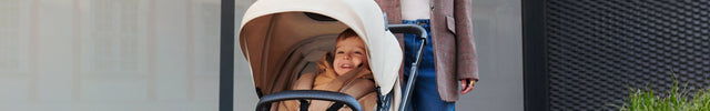 A Woman with her baby inside the Kinderkraft Travel System Newly 3 IN 1 in Sand Beige