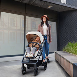 A Woman with her baby inside the Kinderkraft Travel System Newly 3 IN 1 in Sand Beige