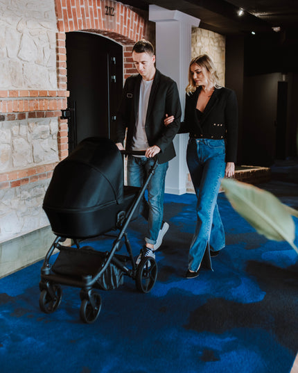 Couple strolling with Kunert ARIZO Stroller in a corridor.