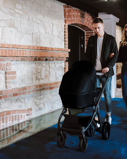 Couple strolling with Kunert ARIZO Stroller in a corridor.