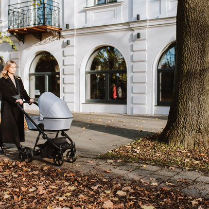 Mother walking with Kunert ARIZO Stroller on autumn day.