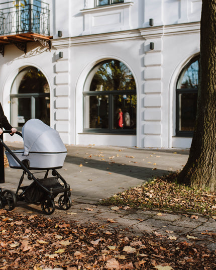 Mother walking with Kunert ARIZO Stroller on autumn day.