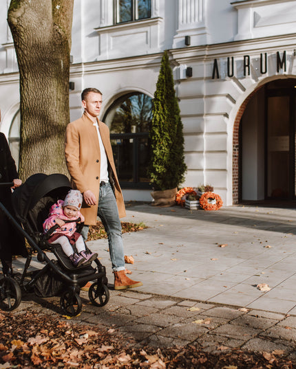 Parents and child with Kunert ARIZO Stroller at entrance.