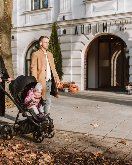 Parents and child with Kunert ARIZO Stroller at entrance.