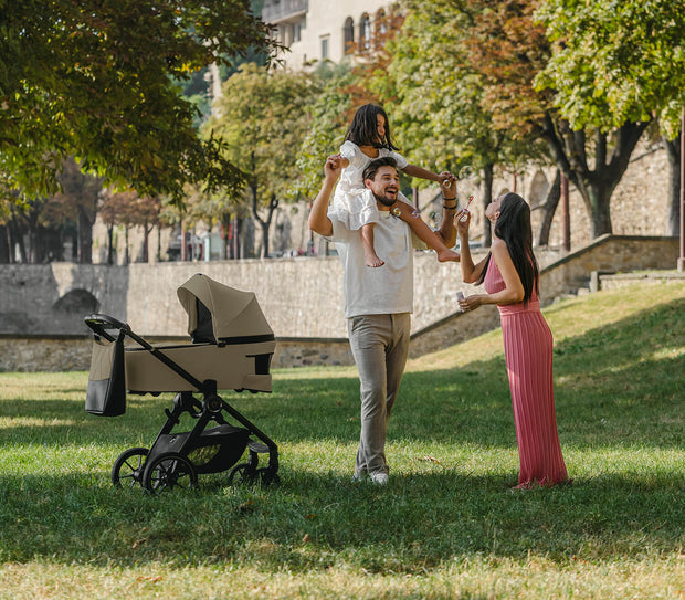 Happy Family playing in the park standing next to Espiro Yoga Stroller
