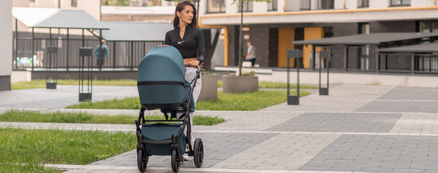 Active mom pushing a Junama Diamond Space Stroller outdoors.