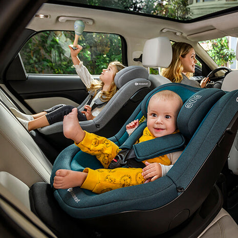 A baby and a toddler inside the car seating in the Kinderkraft Car Seat I-GUARD