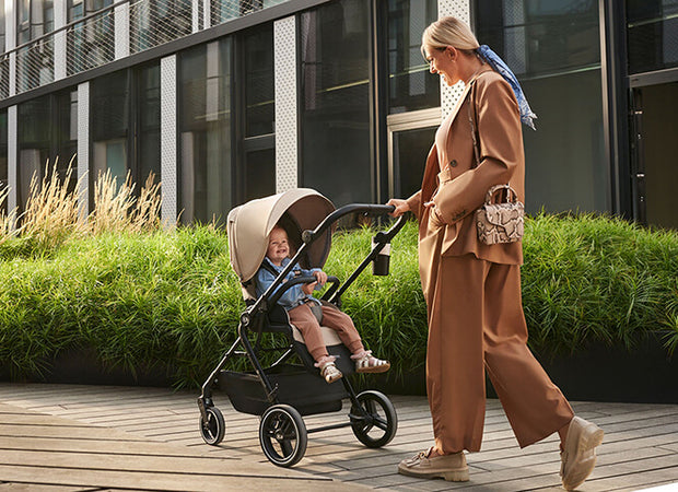 Mother pushing a Kinderkraft Stroller YOXI with her child inside
