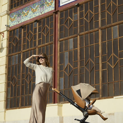 Mima Creo Stroller Mocha - Woman standing next to stroller for a walk in the park.