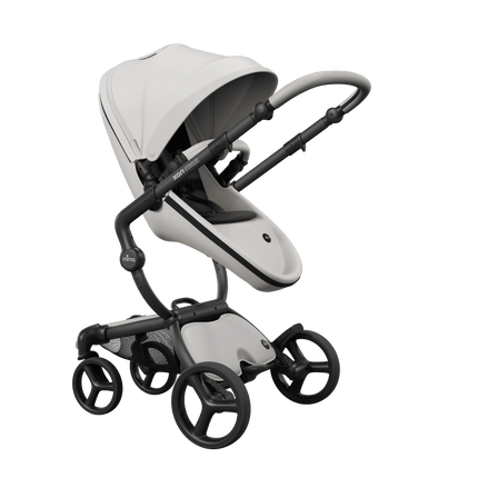 Mima XARI MAX stroller with champagne chassis, snow white seat, and black pad, facing mother.