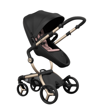 Stylish Mima XARI MAX stroller in black with a pink pad, showcasing a reversible champagne chassis.