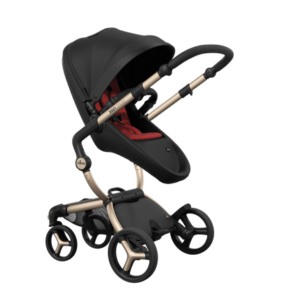 Stylish Mima XARI MAX stroller in black with a red pad, showcasing a reversible champagne chassis.