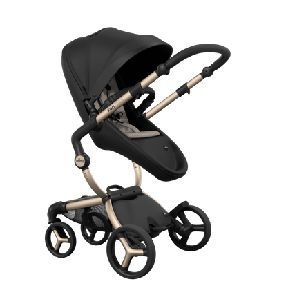 Stylish Mima XARI MAX stroller in black with a sandy beige pad, showcasing a reversible champagne chassis.