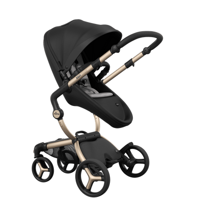 Stylish Mima XARI MAX stroller in black with a white pad, showcasing a reversible champagne chassis.