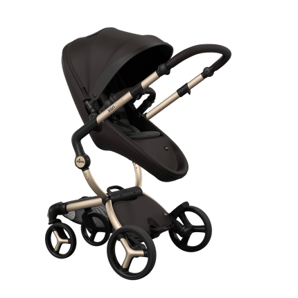 Stylish Mima XARI MAX stroller in chocolate brown with a black pad, showcasing a reversible champagne chassis.