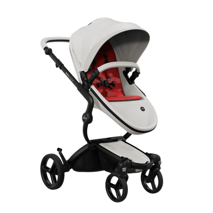 Mima XARI MAX stroller with black chassis, snow white seat, and red pad, facing mother.