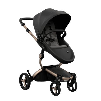 Side view of the Mima XARI MAX stroller, highlighting the black seat and ash brown pad on a durable champagne chassis.