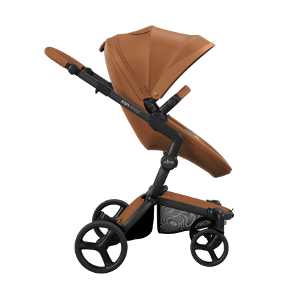 Side view of the Mima XARI MAX stroller, highlighting the camel seat and ash brown pad on a durable black chassis.