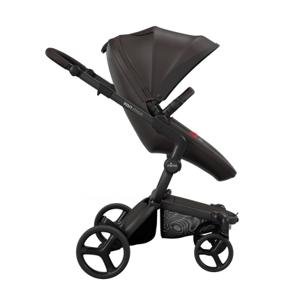 Side view of the Mima XARI MAX stroller, highlighting the chocolate brown seat and red pad on a durable champagne chassis.