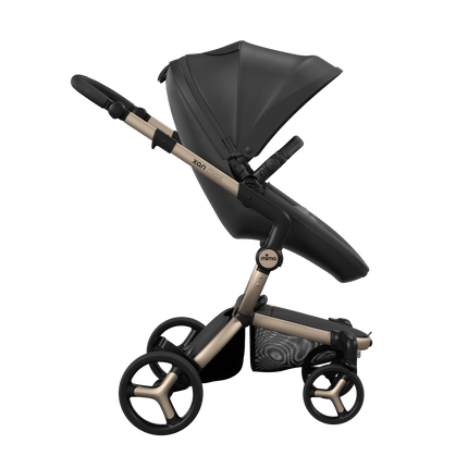 Side view of the Mima XARI MAX stroller, highlighting the black seat and ash brown pad on a durable champagne chassis.