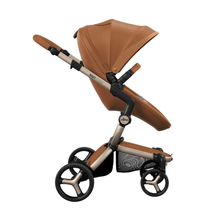 Side view of the Mima XARI MAX stroller, highlighting the camel seat and ash brown pad on a durable champagne chassis.