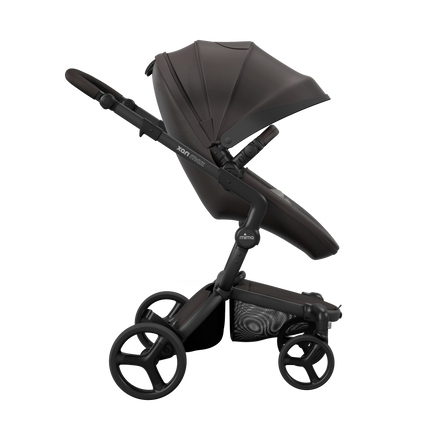 Side view of the Mima XARI MAX stroller, highlighting the chocolate brown seat and ash brown pad on a durable champagne chassis.