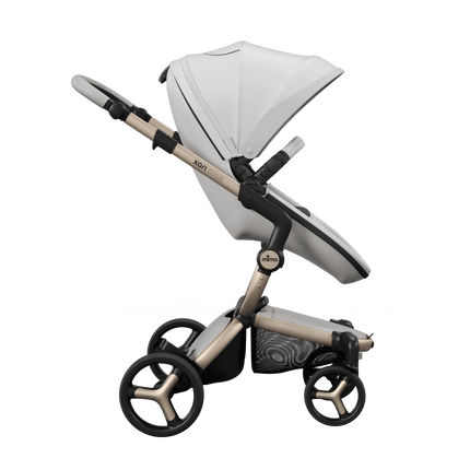 Mima XARI MAX stroller, side view, champagne chassis, snow white seat, black pad. Urban chic with premium comfort.