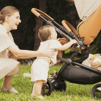 Mima Creo Stroller Mocha in a garden, mom and baby having fun.