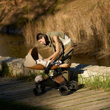 Mima Creo Stroller Mocha by the riverside in a park.