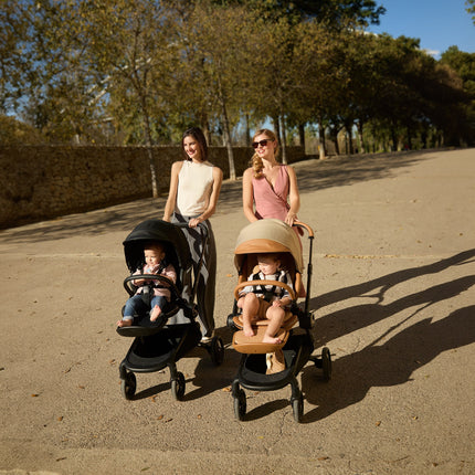 Mima Creo Stroller Mocha on a sunny park walk with two moms and their babies.