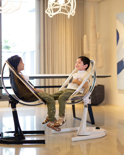 Two children sitting on Mima Moon High Chairs in a bright dining area.