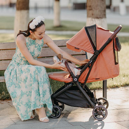 Mother nurting her child inside the Coccolle Lightweight Stroller LEMIRA