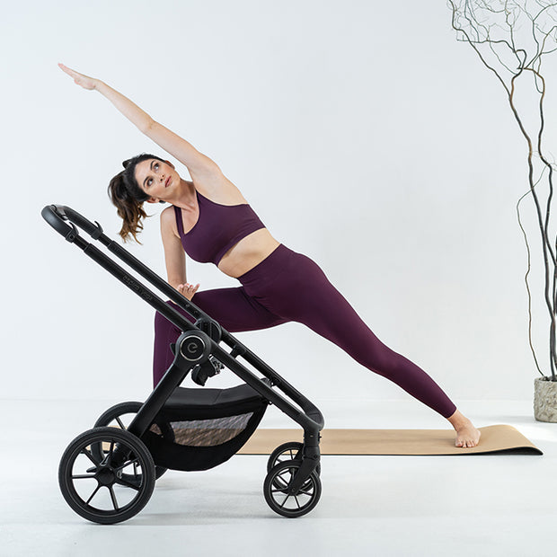 Woman doing yoga near the frame of the Espiro Yoga Stroller