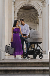 Espiro stroller with a couple on stone steps, framed by classic architecture.