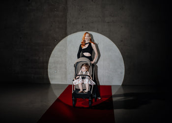 Espiro stroller spotlighted with a woman and child on a red carpet.