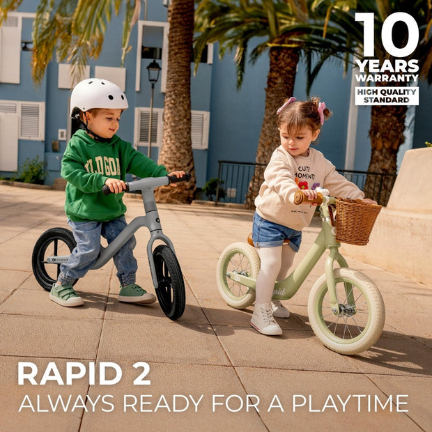 Children playing with Kinderkraft Balance Bike RAPID 2 featuring 10-year warranty.