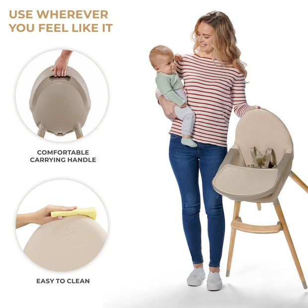 Mother holding baby with a beige Kinderkraft FINI 2 High Chair showing carry handle