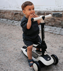 Kinderkraft Tricycle with toddler riding a scooter on a sunny day