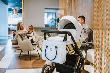 Kunert stroller in a modern lounge with a family relaxing nearby.
