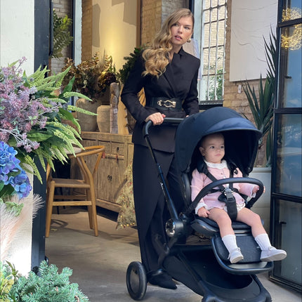 Exploring flowers with the Mima Creo Stroller Black and a child.