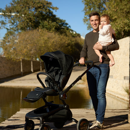 Father and child by the lake with the Mima Creo Stroller Black.