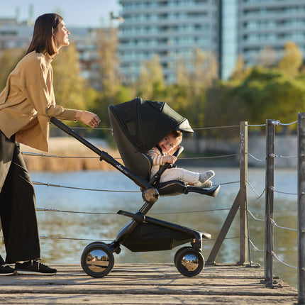 Mother and child enjoying the view by the lake with the Mima Creo Stroller Black.