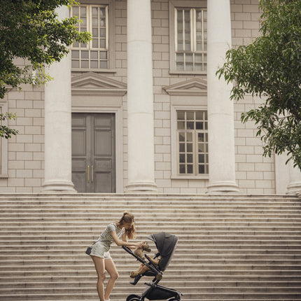 Modern Mima Creo Stroller Black in a park setting with a parent.