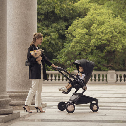 Modern Mima Creo Stroller Black in a park setting with a parent.