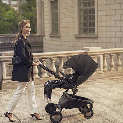 Versatile Mima Creo Stroller Black in a park with a parent and child.