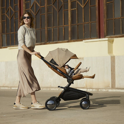 Woman pushing Mima Creo Stroller Mocha with child inside.