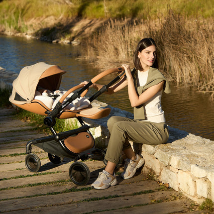 Mima Creo Stroller Mocha woman relaxing on bench by river.